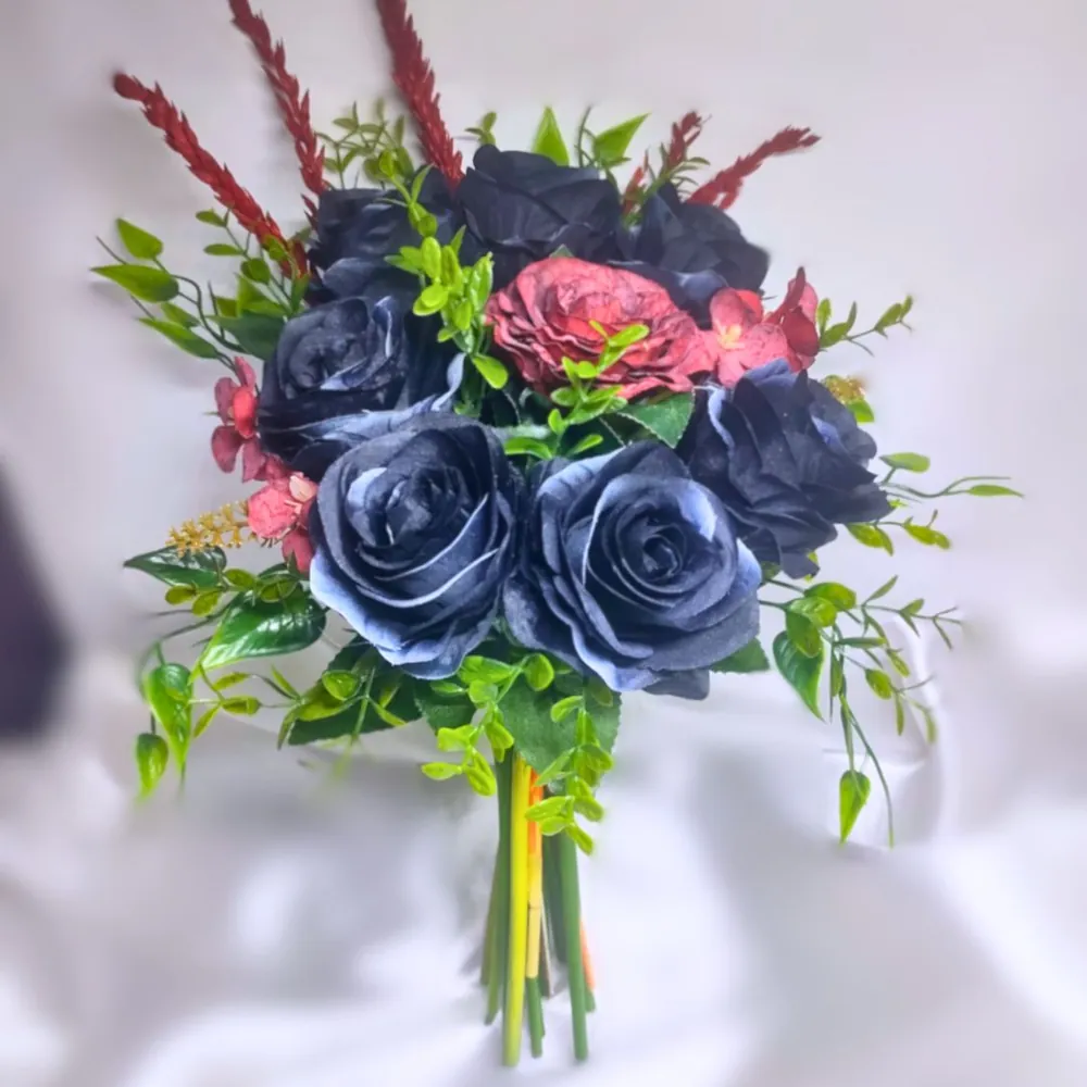 Buquê de noiva semirrealista com rosas azul-marinho, rosas vermelhas, folhagens verdes e galhos de trigo vermelho