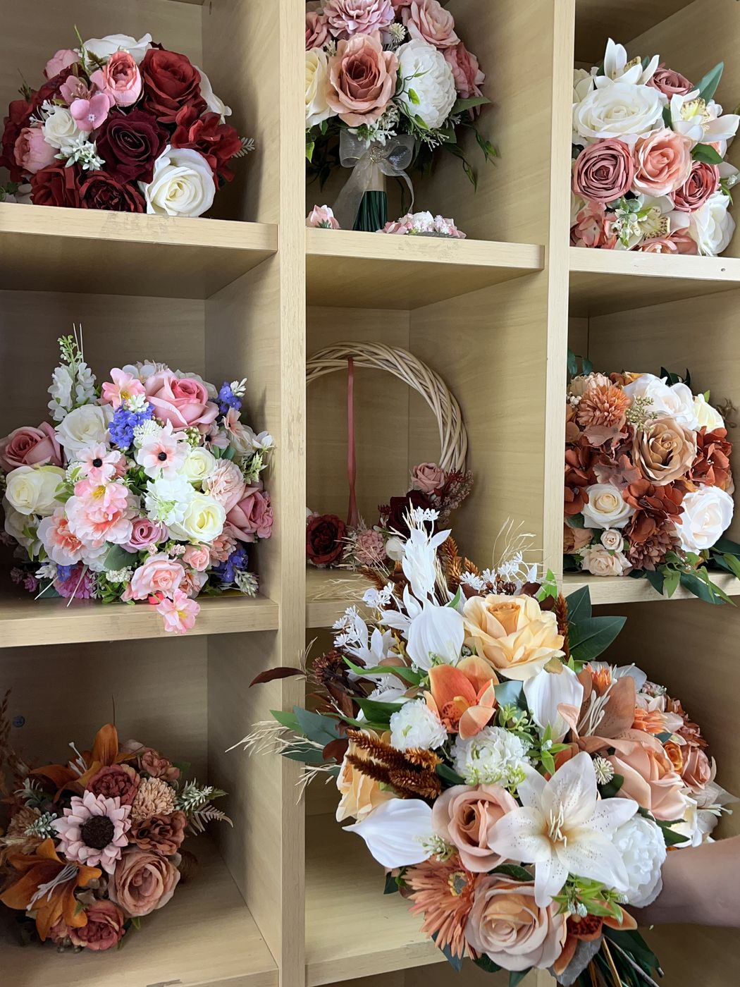 Prateleiras do ateliê com buquês prontos em várias cores